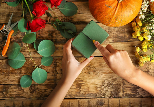 Florist at work. Pumpkin, oasis and tools on wooden background, top view