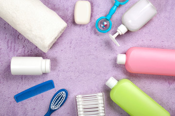 Baby's accessories and cosmetics on fabric background, top view