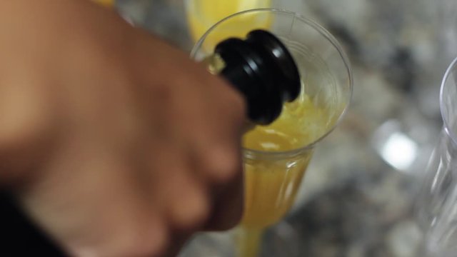 Making a mimosa with champagne and orange juice