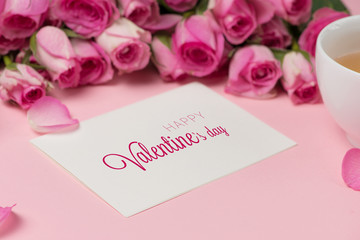 Valentine's Day greeting card with rose flowers over wooden background. Top view with copy space