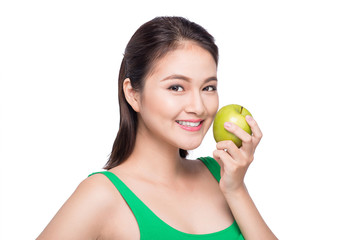 Attractive smiling young asian woman eating green apple isolated over white background.