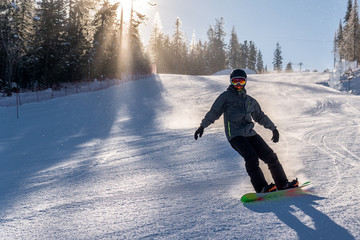 Snowboarder slides down the snowy hill