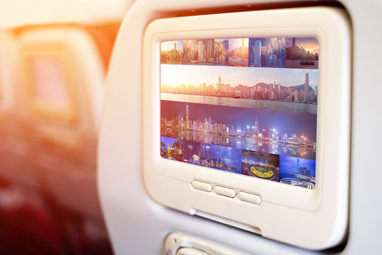Aircraft monitor in front of passenger seat showing panoramic Victoria Harbour view, Hongkong