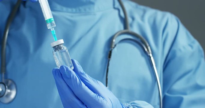 A doctor or scientist in laboratory holding a syringe with liquid vaccines for children or older adults, or cure animal diseases. Concept:diseases,medical care,science, anesthesia,euthanasia,diabetes.