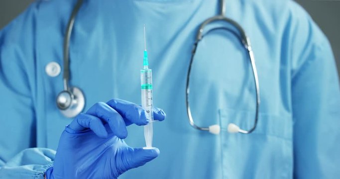 A doctor or scientist in laboratory holding a syringe with liquid vaccines for children or older adults, or cure animal diseases. Concept:diseases,medical care,science, anesthesia,euthanasia,diabetes.