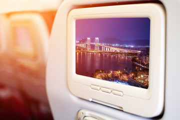 Aircraft monitor in front of passenger seat showing Bridge in Macau view at night