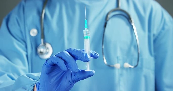A doctor or scientist in laboratory holding a syringe with liquid vaccines for children or older adults, or cure animal diseases. Concept:diseases,medical care,science, anesthesia,euthanasia,diabetes.