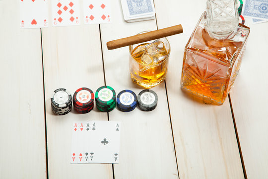 game of poker and a glass  whiskey with ice on  white wooden background