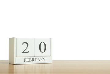 Closeup surface white wooden calendar with black 20 february word on blurred brown wood desk isolated on white background with copy space , selective focus at the calendar