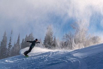 Snowboarder slides down the snowy hill