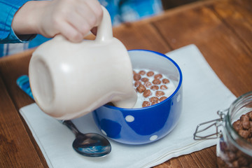 Кукурузные шоколадные шарики в чашке с молоком на завтрак.