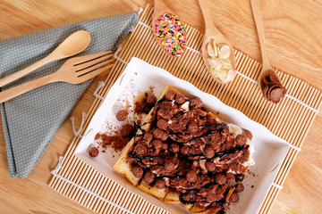 Butter toast with chocolate topping on wood background.