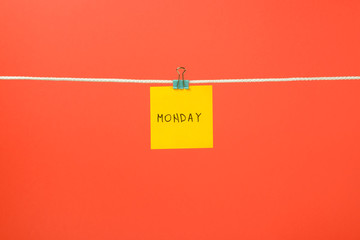 Yellow paper sheet on the string with text “Monday”