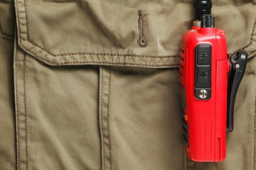 The old portable radio put on pant pocket represent the adventure wear and communication equipment concept related background.
