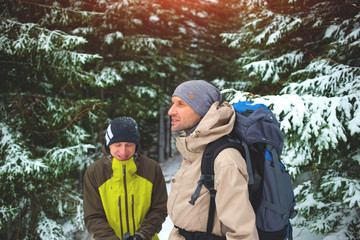 Fototapeta na wymiar Friends with backpacks in the forest in winter.