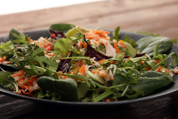 Fresh diet fitness salad of daikon radish, carrots, flax seeds, arugula. Vegan cuisine.