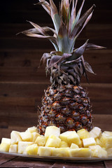 Pineapple tropical fruit / Ananas with slices over wooden table / Rustic, country style