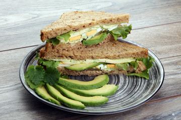 Sandwich with avocado and poached egg - healthy breakfast concept