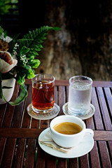   Save Download Preview Vignette Espresso coffee in glass cup on the wood table with in garden background.