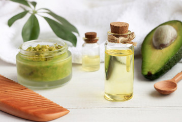 Obraz na płótnie Canvas Home spa. Avocado oil facial mask, oil in bottle, white and green towels. Natural skincare treatment.