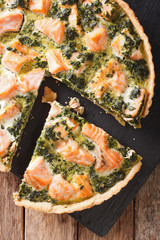 Sliced Quiche with salmon, spinach and cream close-up. vertical top view