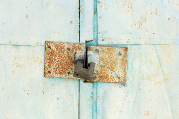 iron lock. Old iron door closed behind the lock. Green background