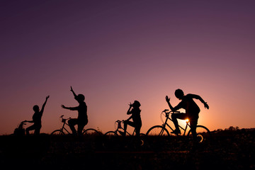 Fototapeta na wymiar Silhouette of happy friends on bicycle