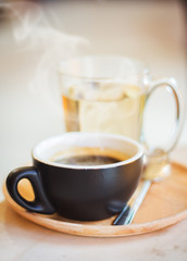 Close up coffee cup with steam on table in cafe.