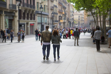 Couple walking down the streets of Barcelona, Spain. Light tilt shift effect.