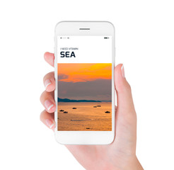 Woman hand shows aerial view of the sea at sunrise on smartphone display isolated on white background