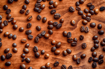 background of beans of roasted coffee on a wooden table