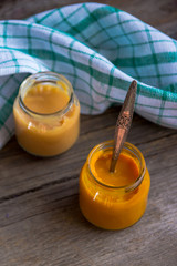 Glass jars with natural baby food on the wooden table