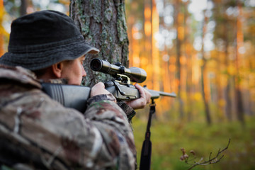 Hunter looking into rifle scope - obrazy, fototapety, plakaty