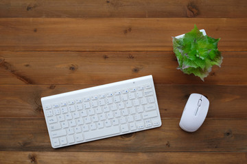 Keyboard and mouse on wood table background, with copy space for text