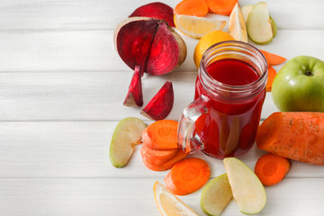 Natural detox beetroot smoothie with ingredients on white wood background