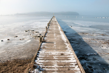 Fototapeta premium Bootsanlegesteg auf der zugefrorenen Ostsee Insel Rügen