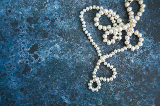 White pearl necklace on a blue backround