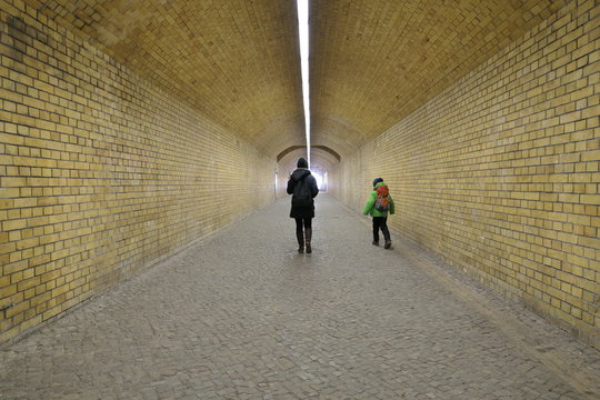 Mother and child walking through an underpass