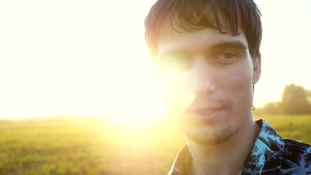 Portrait of smiles man looking at the sun during beautiful sunset with lense flare effects. 3840x2160