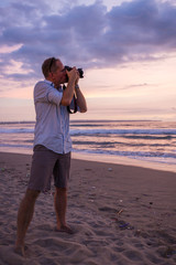 Photographer on the beach at sunset