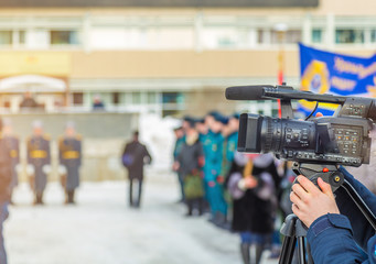 Cameraman shooting a military parade in the winter