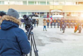 Cameraman shooting a military parade in the winter