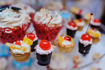 sweet cupcakes with cherry, kiwi, orange