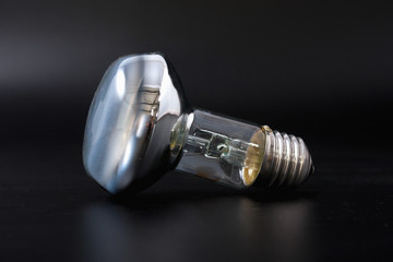 economical light bulb on a black background.