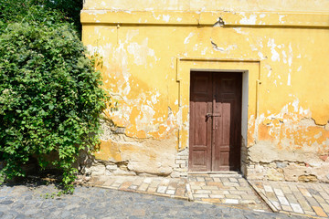 Fototapeta na wymiar Wooden door to the old yellow house