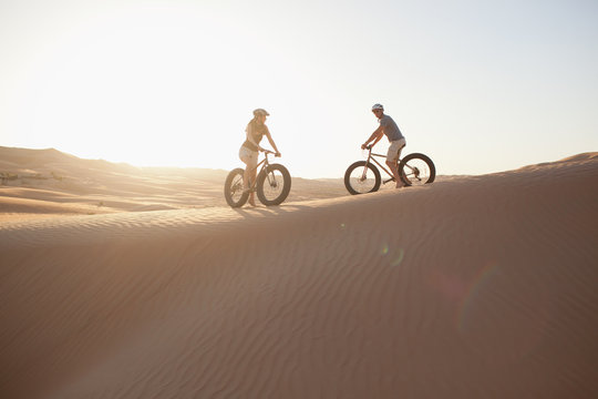 Couple with bicycle on desert.
