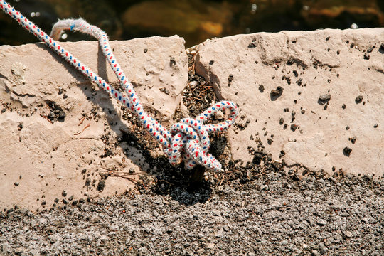 Fishing white colorful rope tied to a hook, close-up