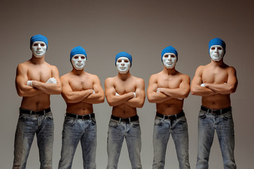 The group of caucasian men in white masks and hats, jeans - obrazy, fototapety, plakaty