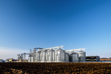The complex silo installations for the storage of grain standing in the plowed © yanik88