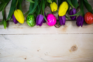 Tulpen mit Ostereiern auf Holz